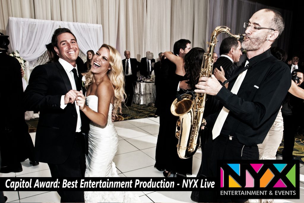 Bride and groom dancing joyfully while a live saxophonist plays at their wedding reception, showcasing the energy and elegance of hiring a live band.
