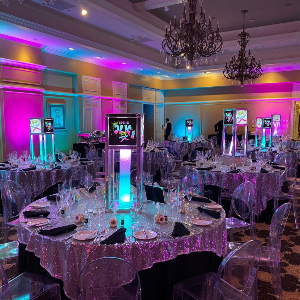 Intelligent lighting design for weddings in Baltimore MD featuring pink and teal uplighting with glowing centerpieces at a formal event reception