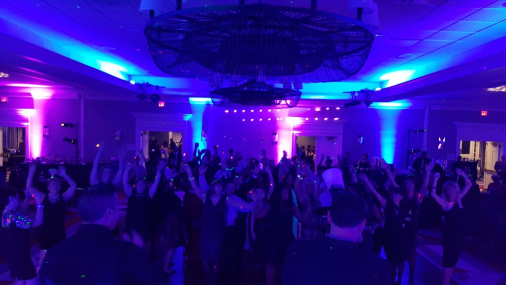 Guests dancing under purple and blue uplighting at a NYX Events disco-style party
